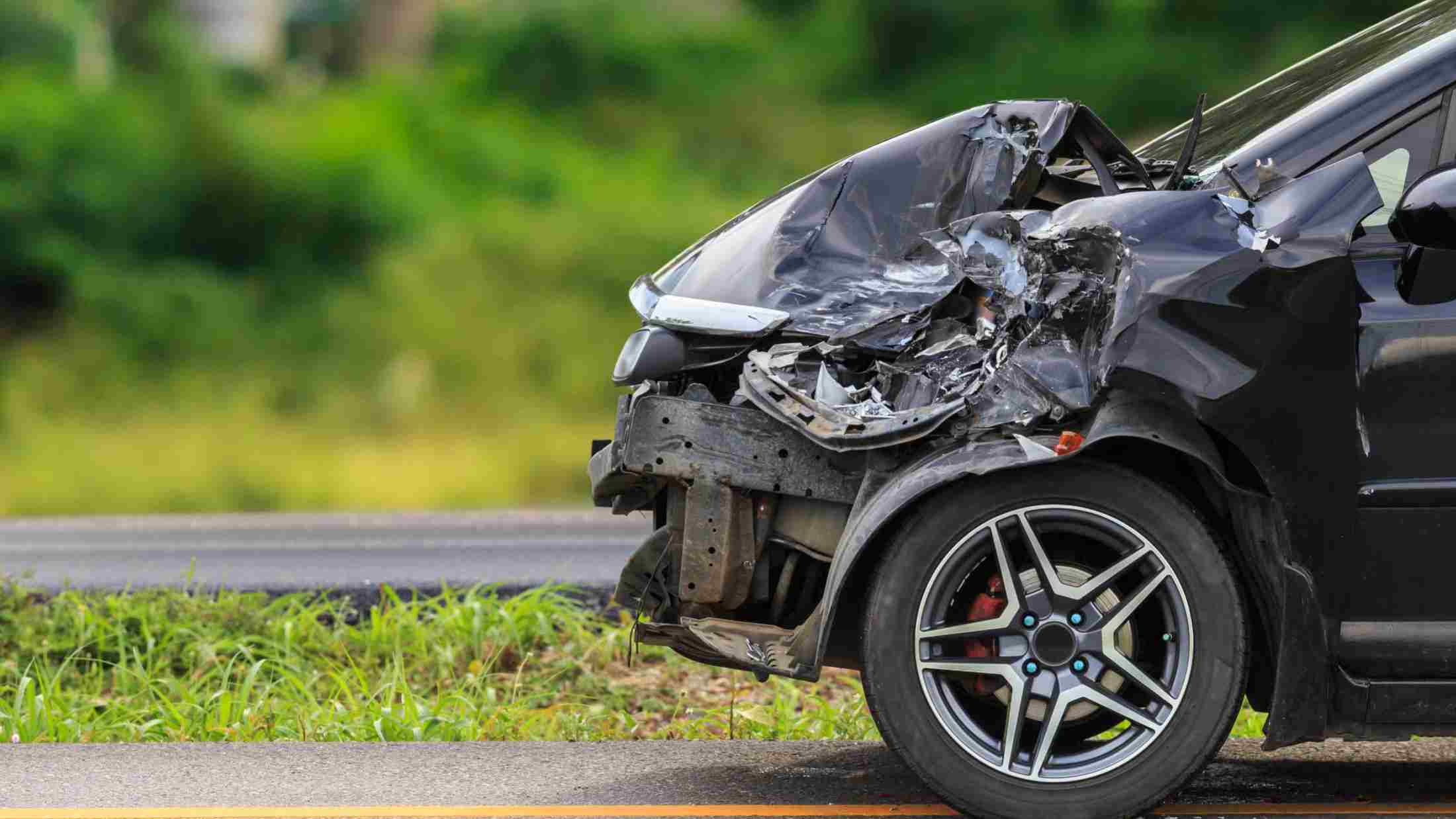 A crashed car parks by side of road