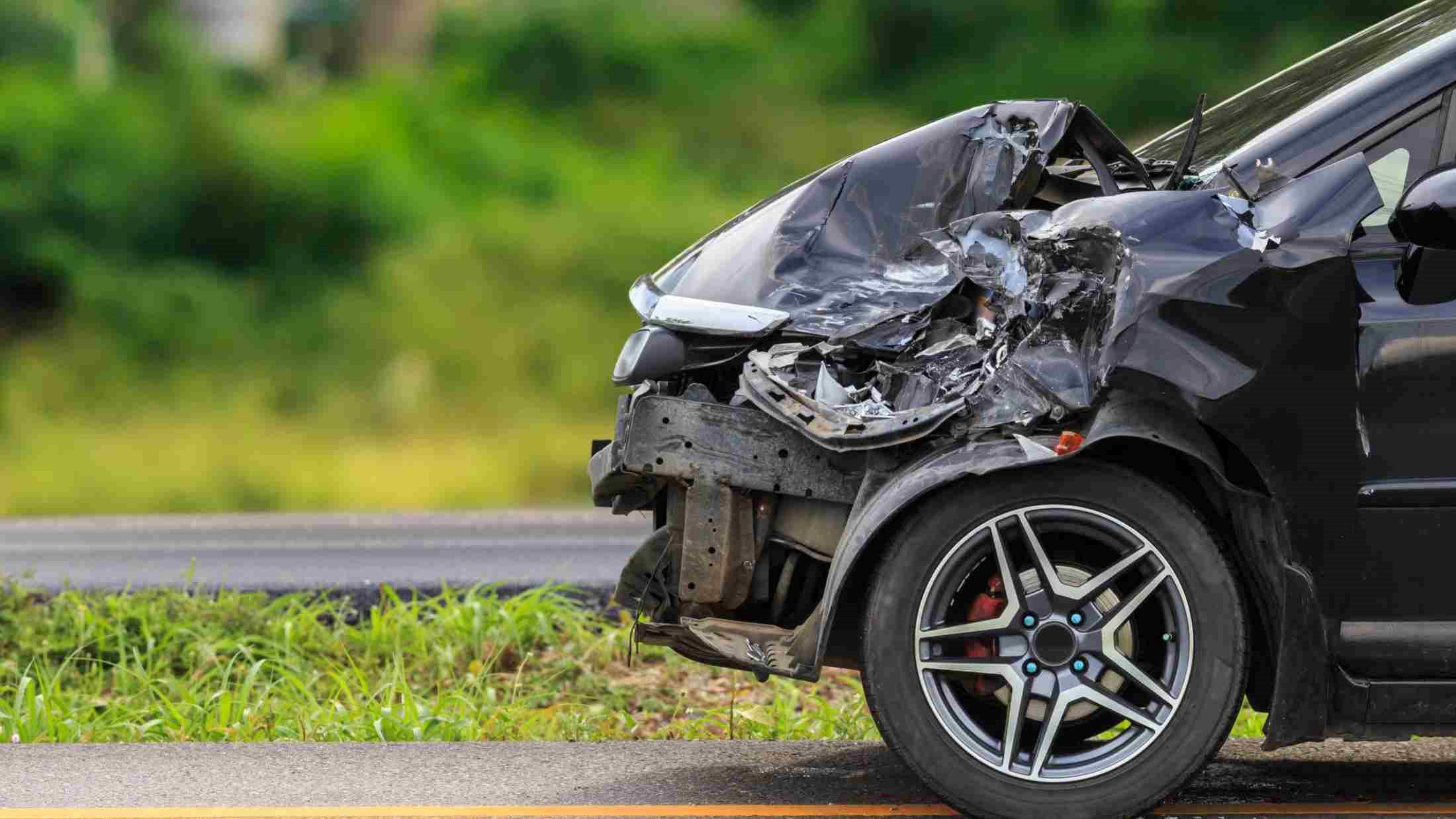 A crashed car parks by side of road