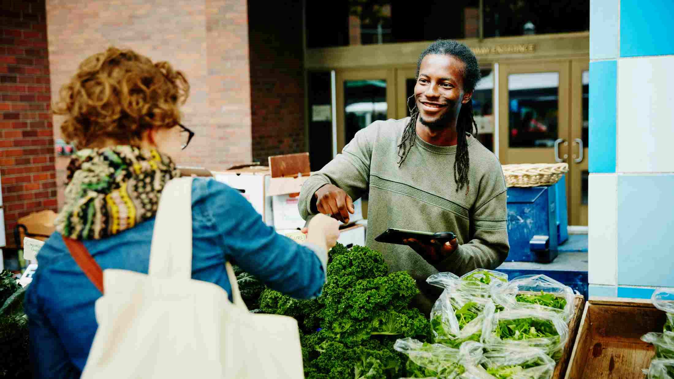 Green grocer taking credit card payment from customer