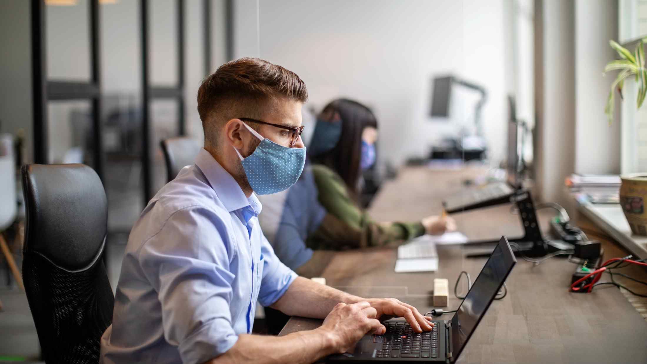 Businessman wearing protective face mask working at his desk