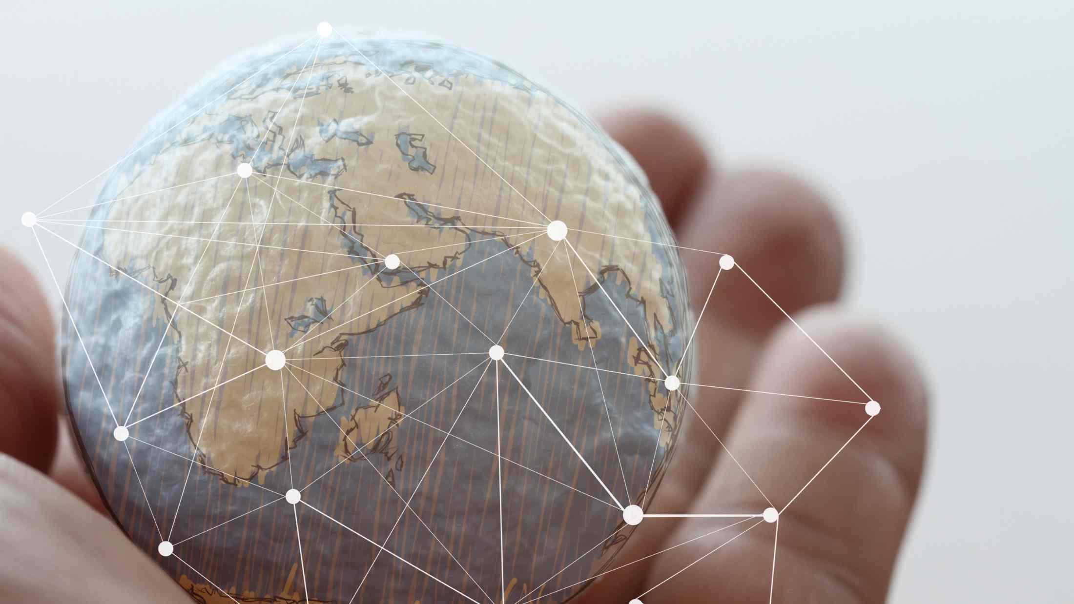 Hand holding a small world with digital social media network diagram