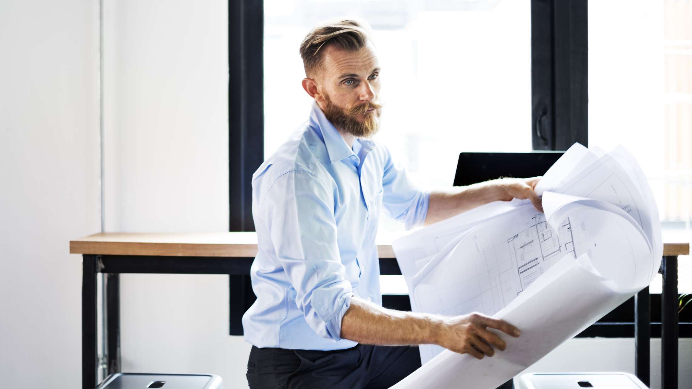 Man holding blueprint plans