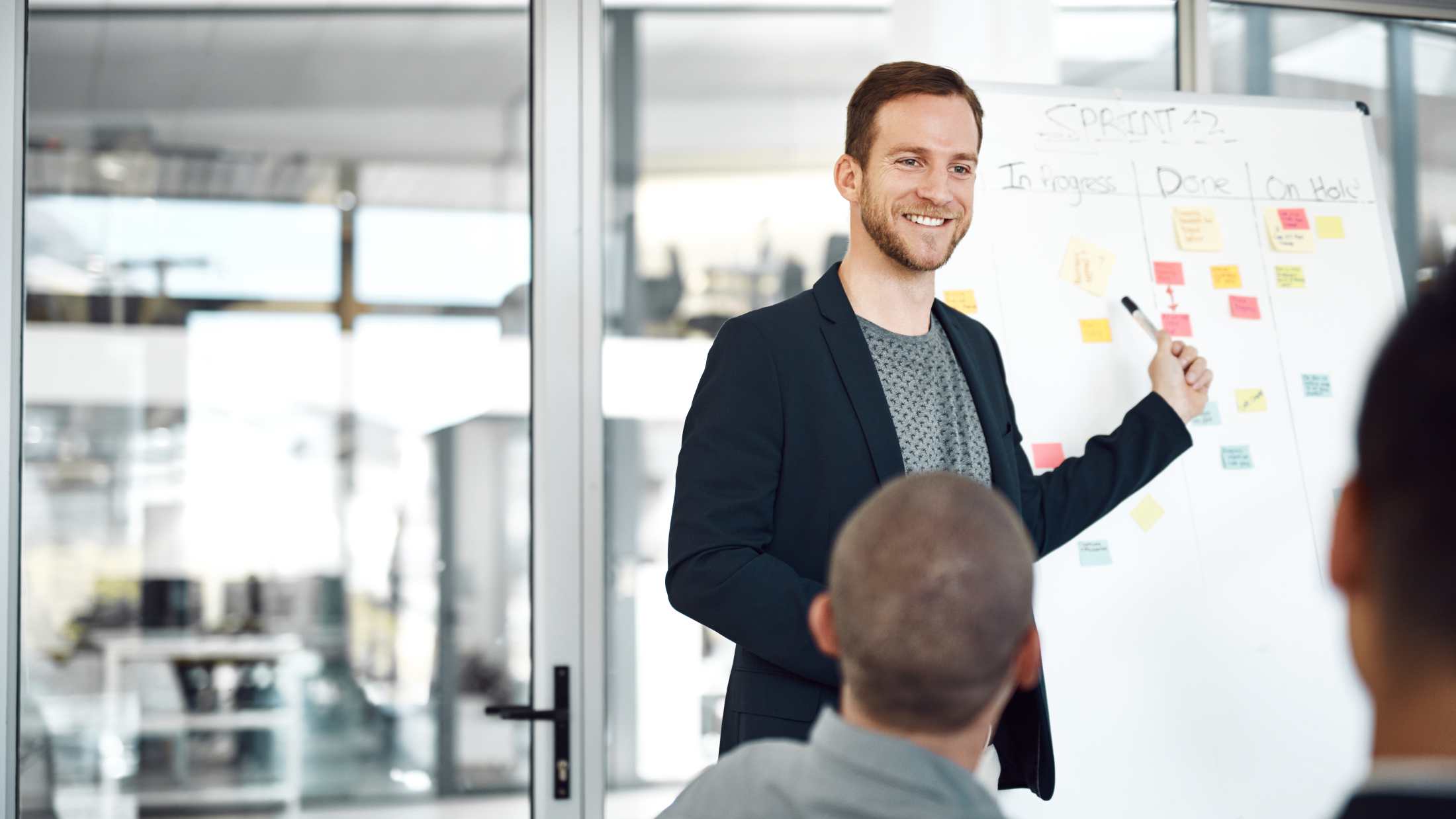 Man stood up pointing to a flip chart
