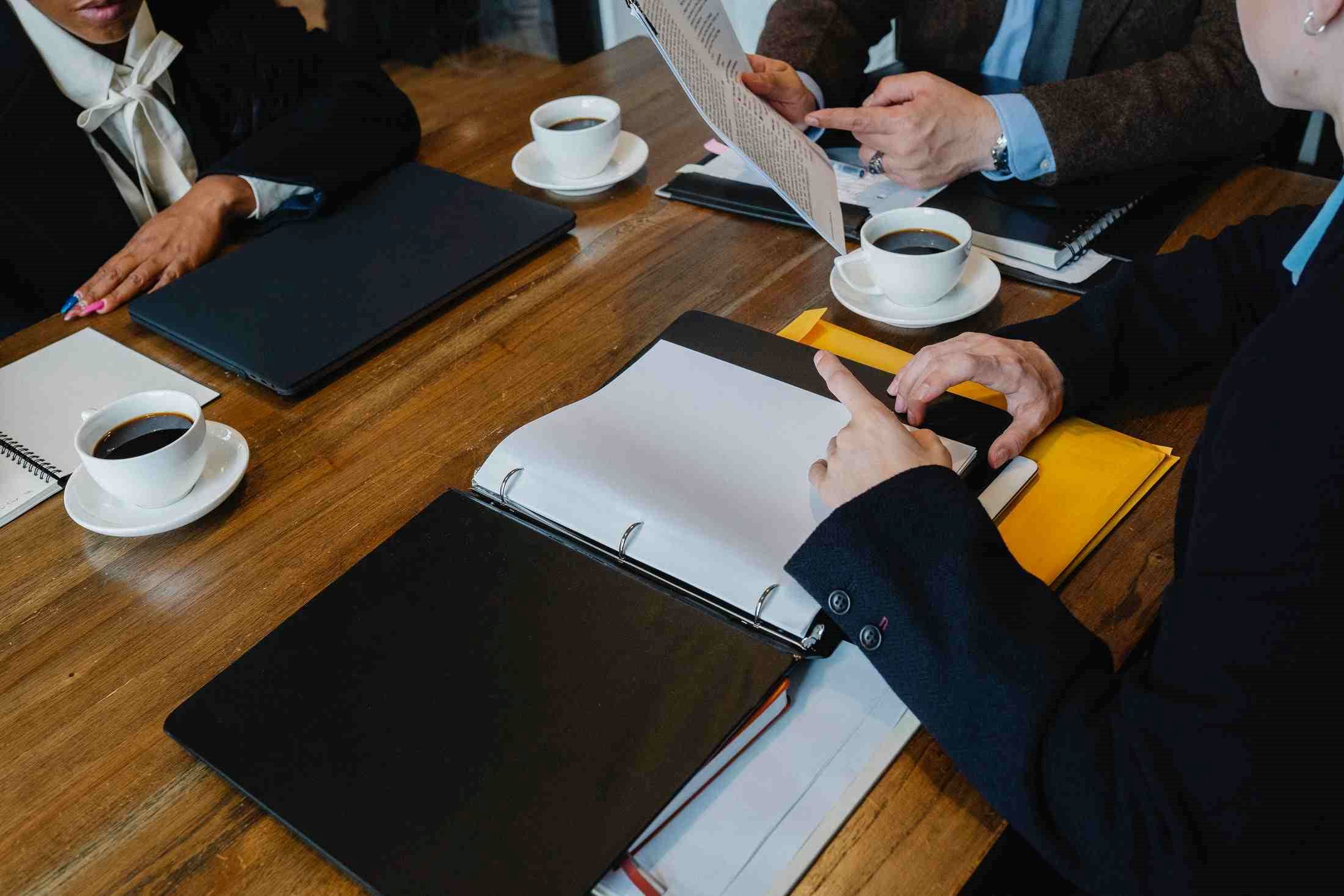 Colleagues discussing business proposals over coffee