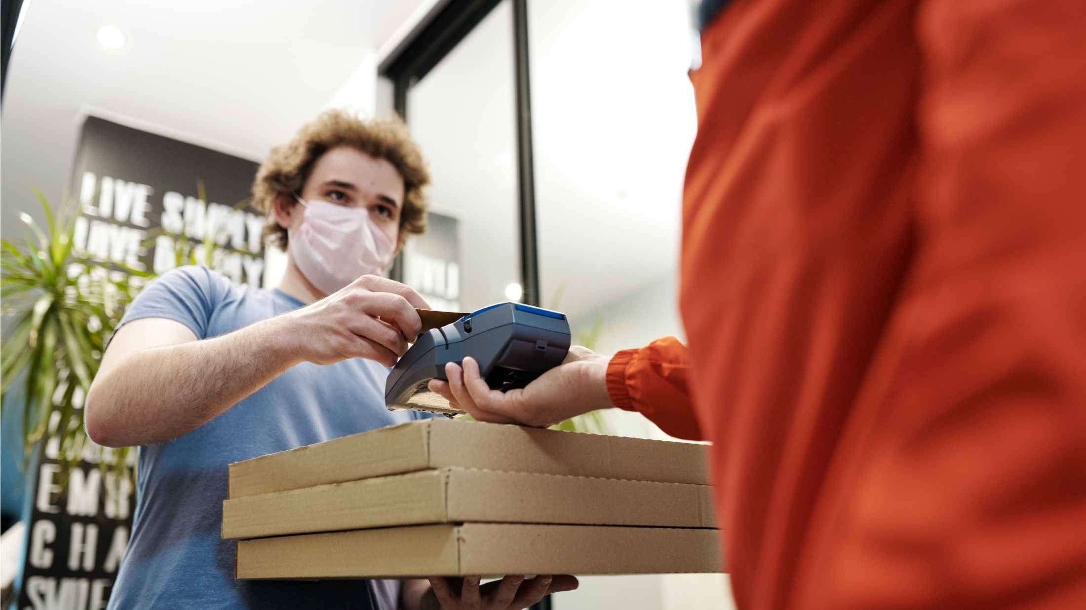 Man paying for items while wearing a face mask
