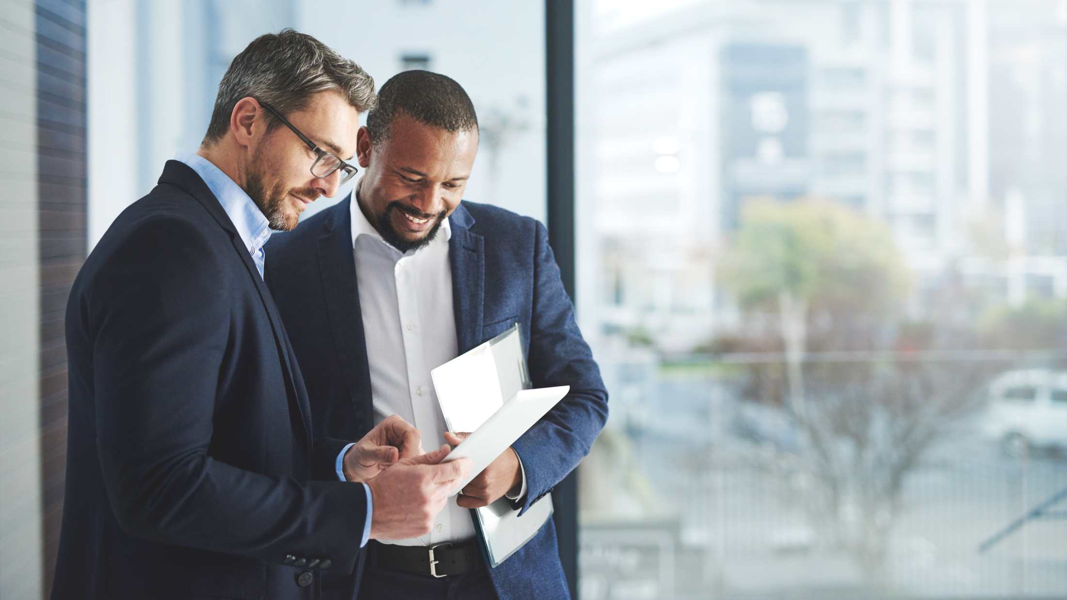 Two business men talking in smiling in office
