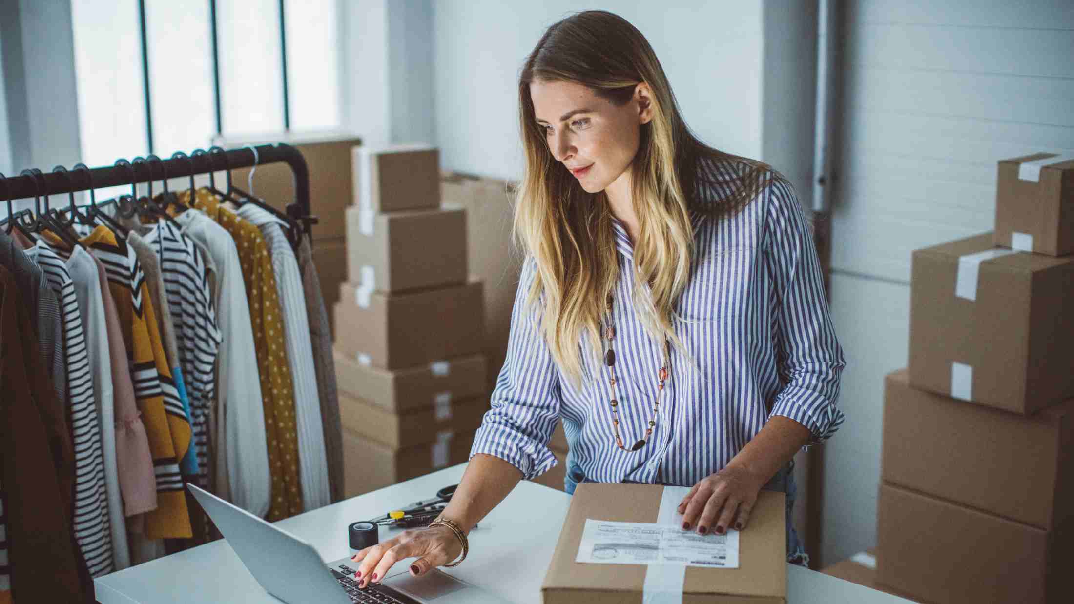 Women, owner of small business packing product in boxes, preparing it for delivery
