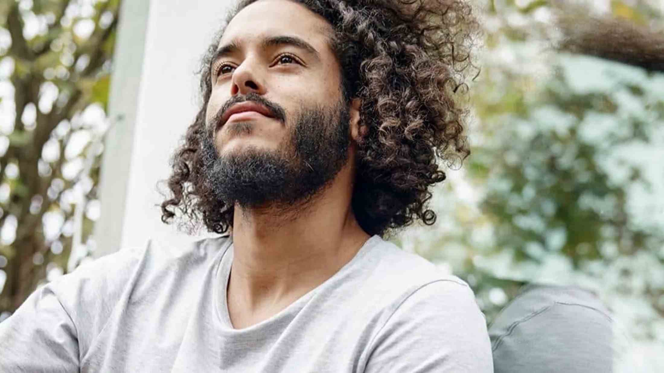 A man sitting in front of his house with smile